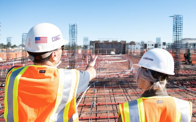 man in white hard hat standing on brown wooden dock during daytime